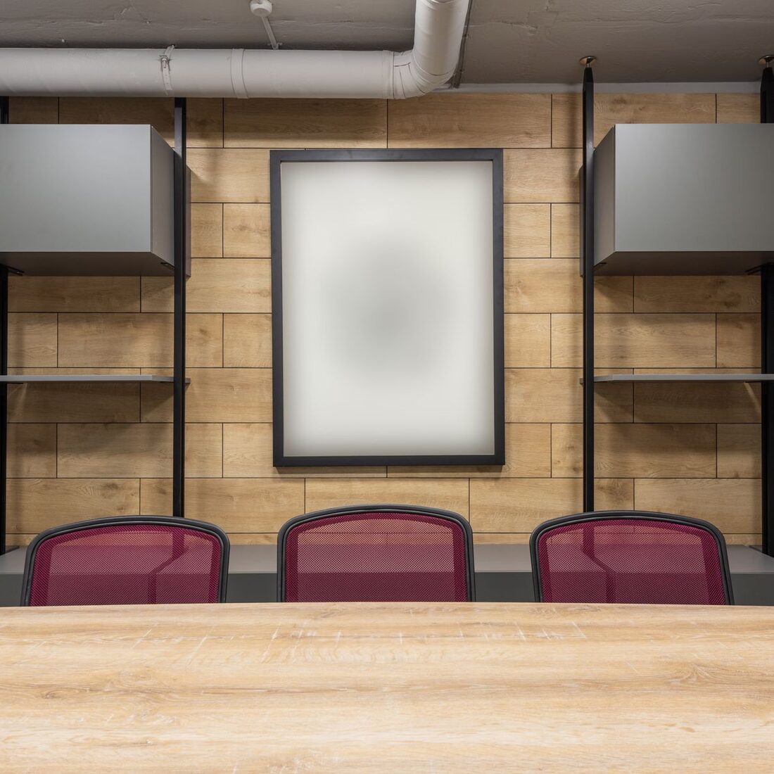 Meeting room with a timber-slat feature wall, long table and upholstered chairs