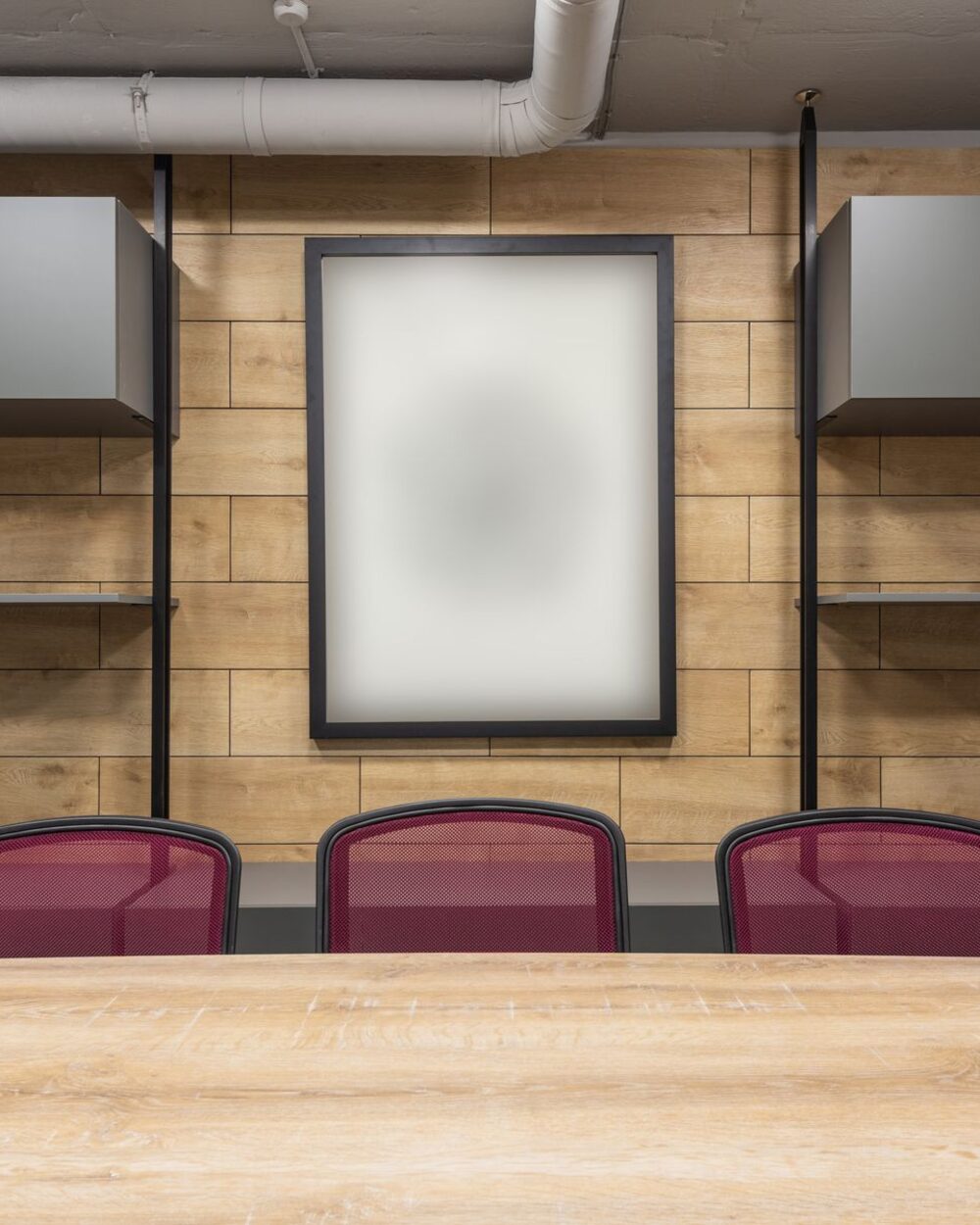 Meeting room with a timber-slat feature wall, long table and upholstered chairs